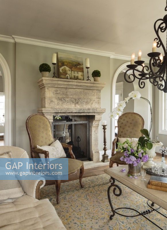  Lorna had the walls designed around this antique French fireplace; they are extra thick to house the two-way limestone beauty. Sheâ€™s owned the carved chairs for more than 20 years. â€œ