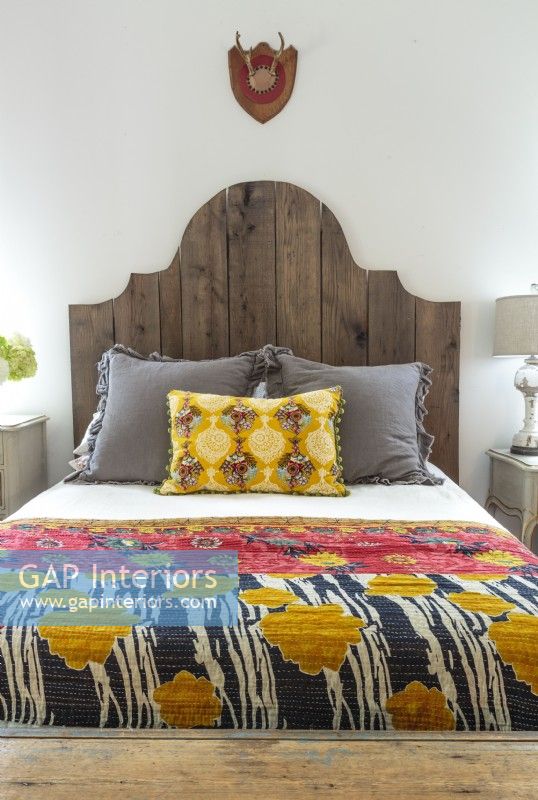 Darryl made the headboard and Annie made the bedspread and pillows; other pieces add deep primary hues to the mix. 