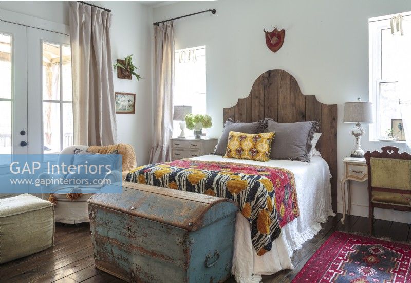  Heritage  pieces from Darrylâ€™s grandmother make elegant nightstands while an antique steamer trunk offers stylish storage the foot of the bed. 