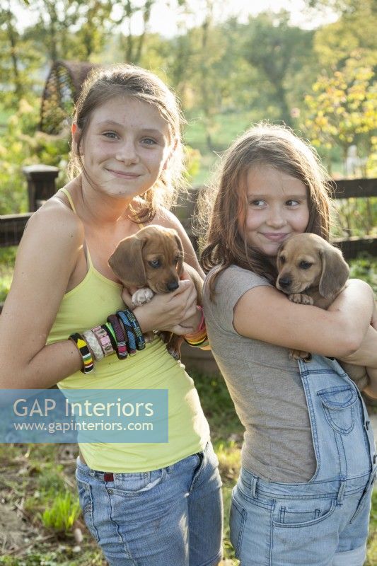 Daughters Sophie and Gweneal share playtime with their pets.
