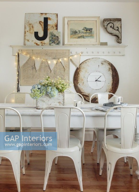  A Belgian grain sack with its seams removed runs along the farmhouse table. A giant clock constructed from a bistro tabletop rounds out the gallery wall. 