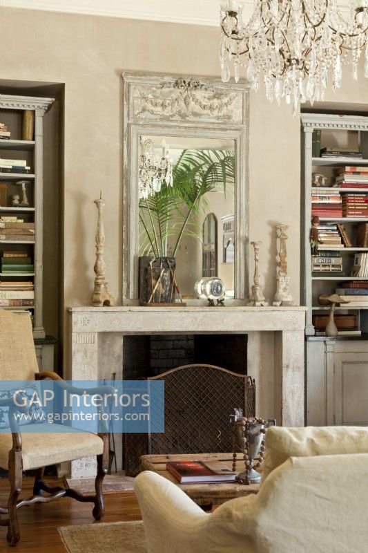 Custom-made bookcases stand on each side of the a 19th century limestone fireplace surround. 