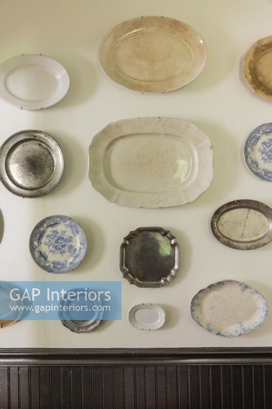 A curated mix of aged china and pewter dishes.