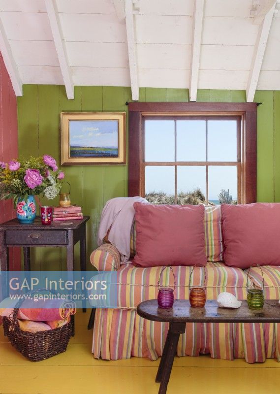 The sofaâ€™s candy-striped upholstery echoes the coats of many colors throughput the house. 