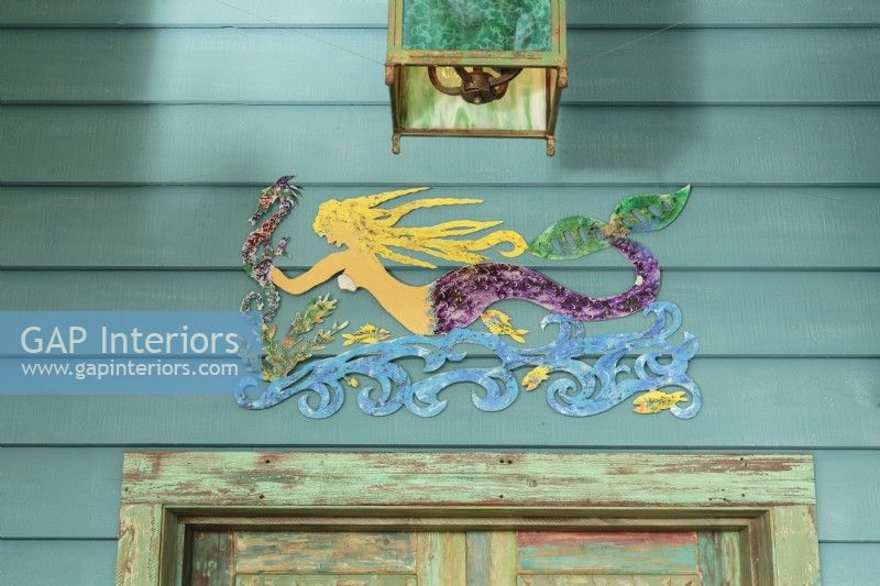 A mermaid sculpture announces the cottage waterside location.