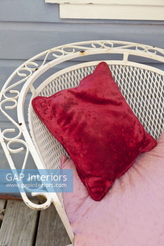 Velvet cushions cozy up iron chairs.