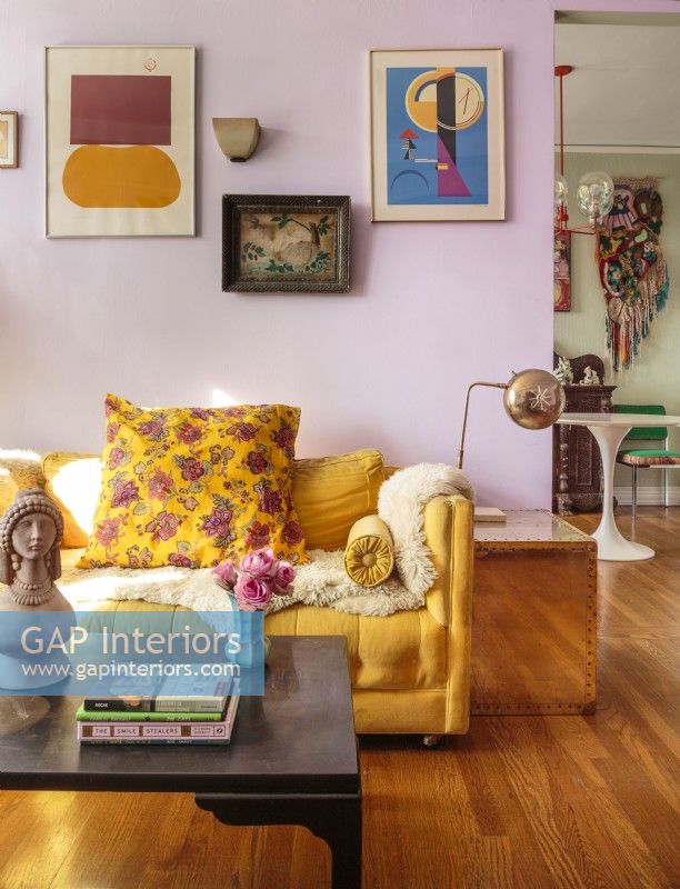 To balance the lavender walls and yellow sofa, Bridget uses rich blues and dark reds.