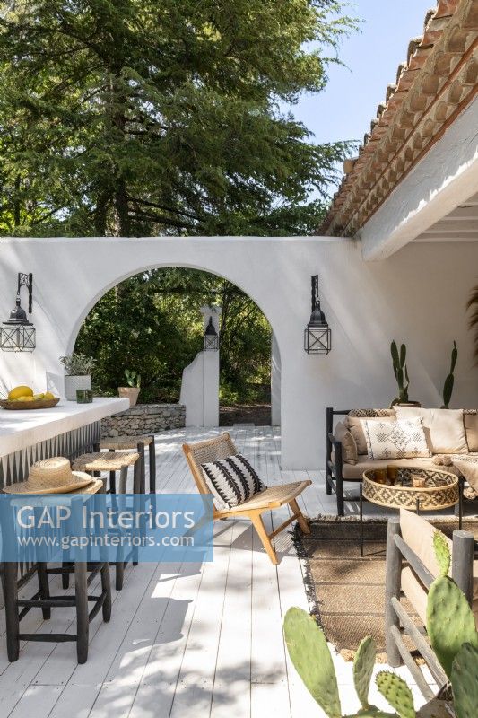 Decked outdoor living space in Mediterranean style garden