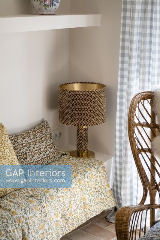 Gold metal lamp in corner of living room with vintage fabrics
