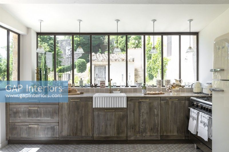 Distressed wooden country kitchen with garden views in summer