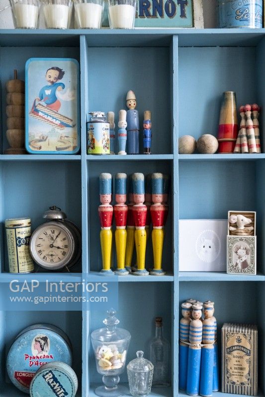 Blue painted shelves with vintage toys and ornaments