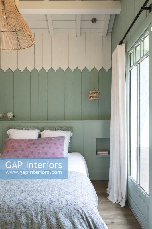 Pastel blue and white painted wooden walls in country bedroom