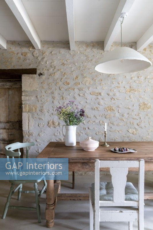 Exposed stone wall in country dining room