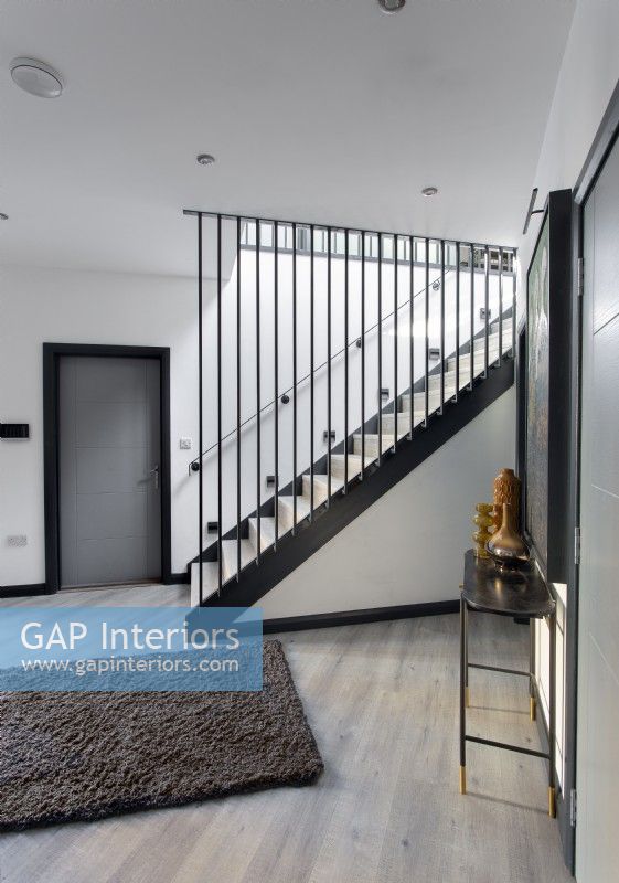 Modern hallway with black metal rails on staircase