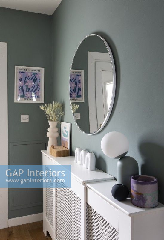 White radiator cover shelf and mirror in grey painted hallway