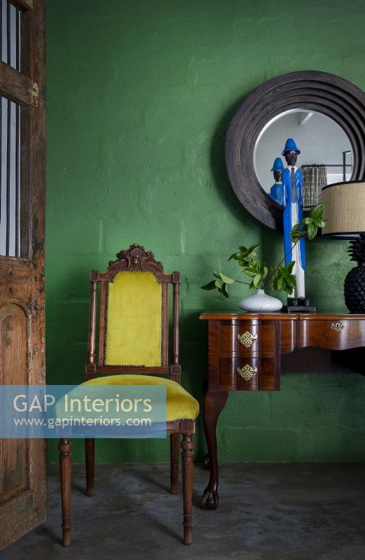 Vintage furniture against green feature wall
