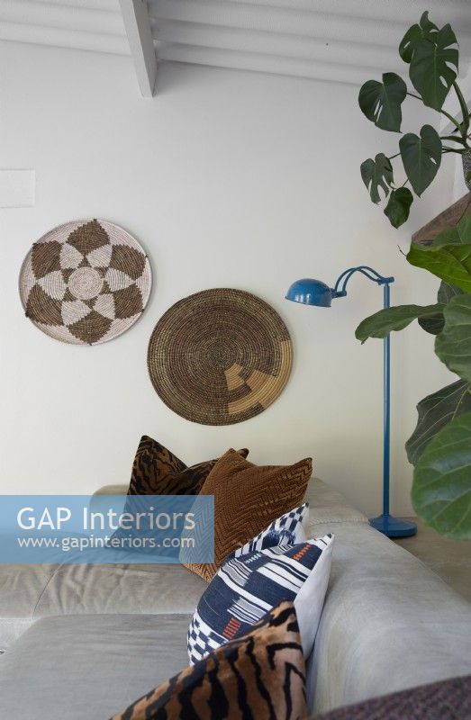 Cushions on sofa and wall mounted woven baskets