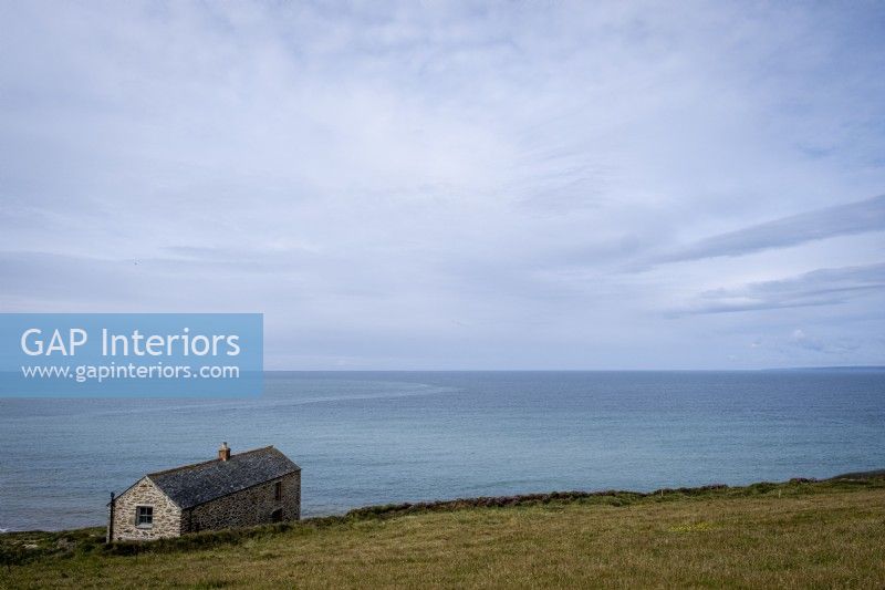 Exterior of old stone barn conversion, formerly a 'fish cellar' on the cliff at Gunwalloe, Cornwall