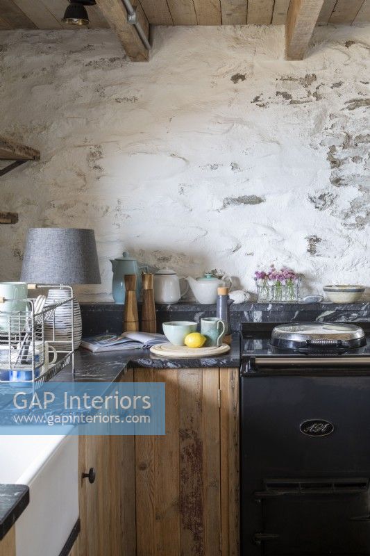 Kitchen worktop with Aga cooker and white washed walls