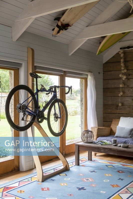 Converted barn, Mountain bike hangs from a designer wooden frame, room has open beams and tongue and groove decoration