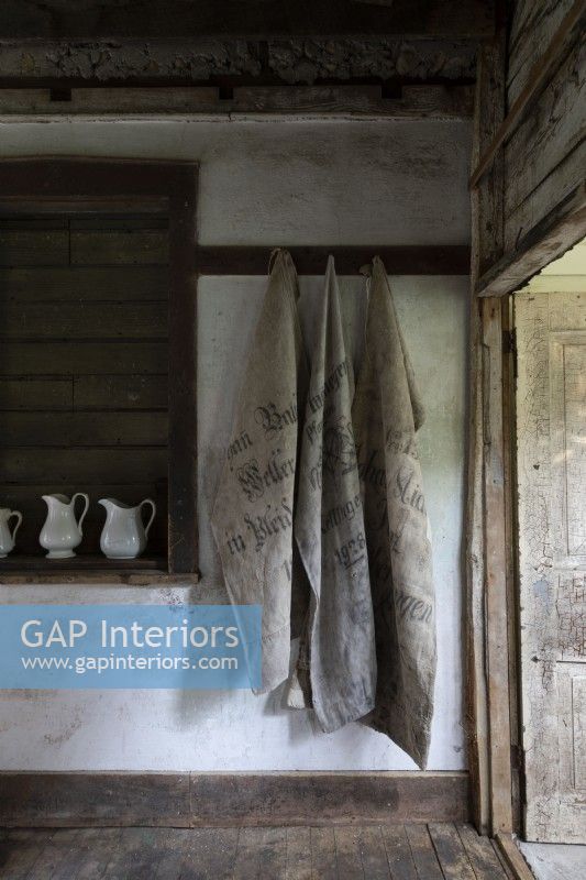 Sacks hanging on clothes hooks in rustic hallway