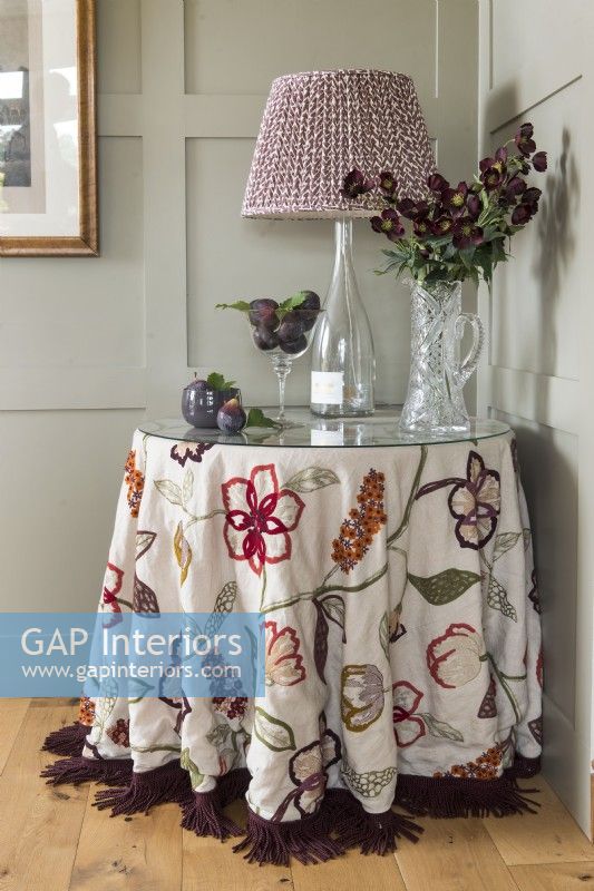 Fabric lampshade on round table with embroidered tablecloth