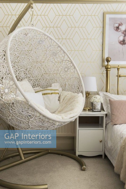 Decorative swing seat in gold and pink themed bedroom