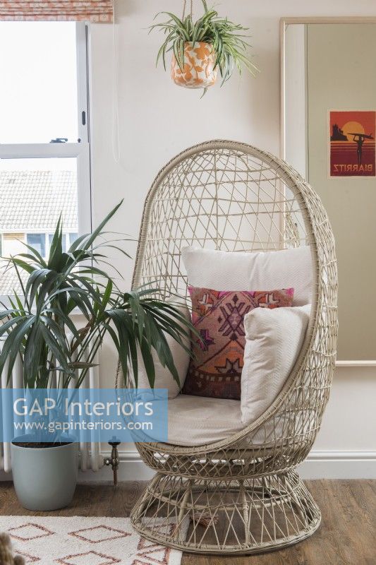 Large wicker cushion filled chair and houseplant