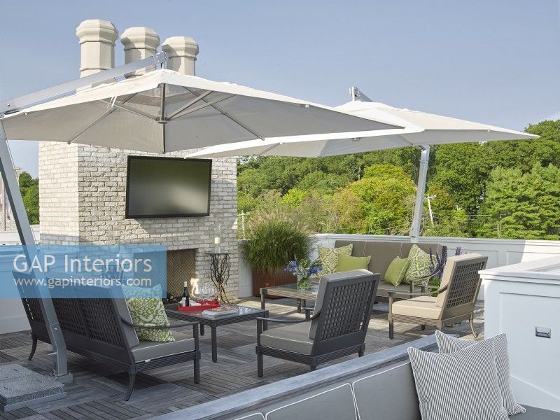 A modern design roof deck with fireplace, TV and umbrellas