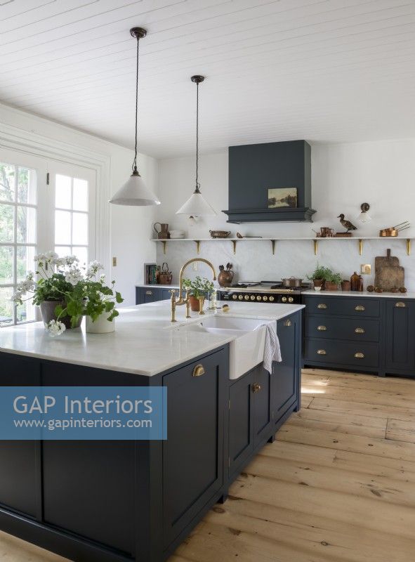 Dark blue cabinets and stripped wooden flooring in modern kitchen