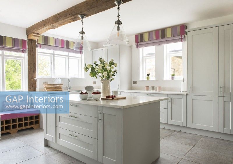 Colourful blinds in white country kitchen with large island