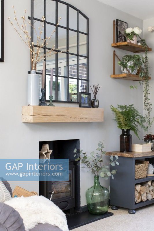 Fireplace with large industrial style mirror over wooden mantle