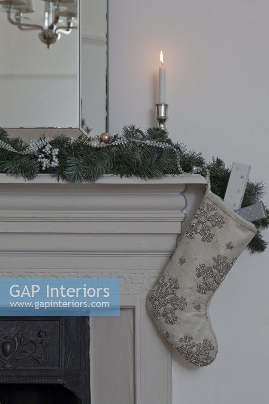 Detail of Christmas mantelpiece with stocking and garland.