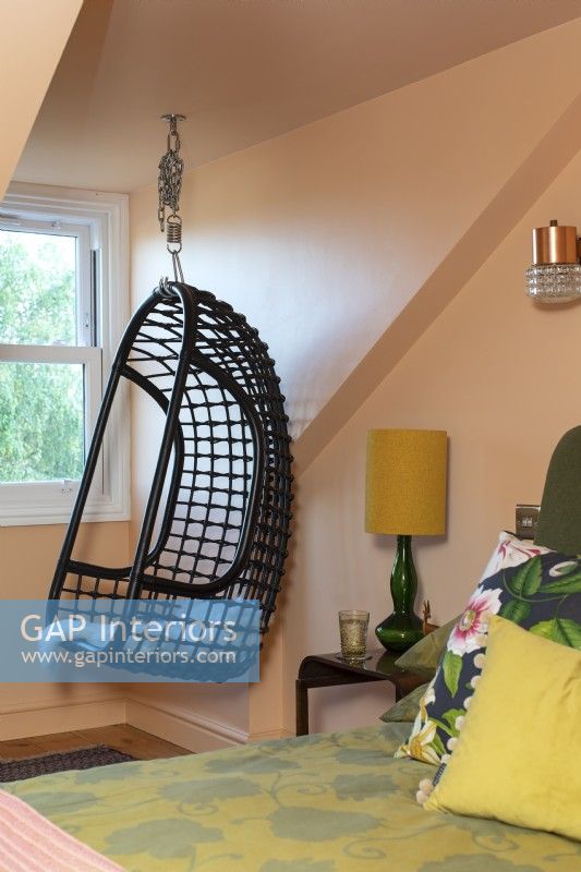 Hanging chair in colourful loft bedroom