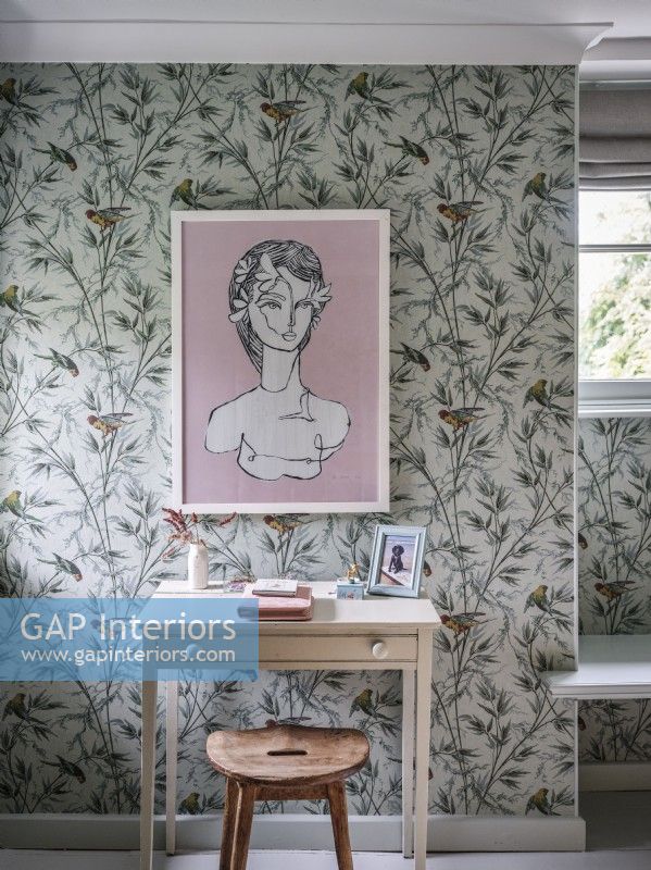 Bedroom desk with botanical wallpaper and framed picture