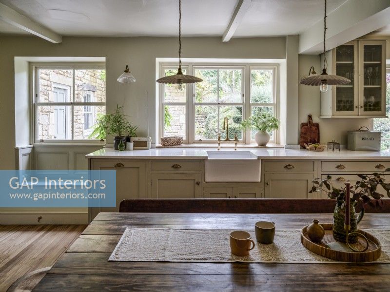 Neutral country kitchen with butler sink and pendant lighting