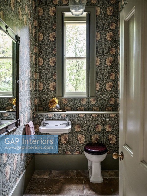 Bathroom with floral wallpaper and stone floor