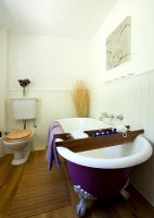 Country bathroom with purple roll top bath