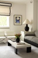 Modern living room with white armchairs, grey sofa and coffee table