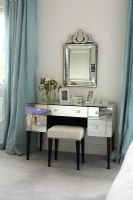 Classic bedroom with mirrored dressing table and ornate mirror and duck egg blue curtains