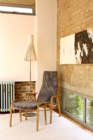 Contemporary living room with Seppo Koho lamp and exposed brick wall