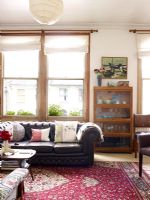 Country living room with leather sofa and large floral rug