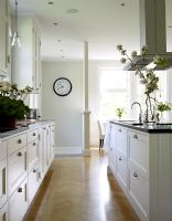 Kitchen with white units and parquet flooring 