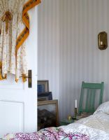 Detail of country style bedroom with wallpapered walls 