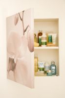 Storage cupboard hidden behind canvas print  in bathroom