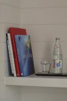 Books and water bottle with glass on shelf