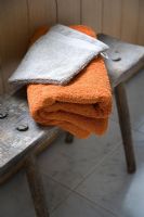 Towels on rustic bench in bathroom, detail