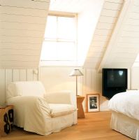 Attic bedroom with white armchair
