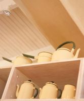 Teapots on kitchen shelf, low angle view