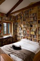Bedroom lined with bookshelves
